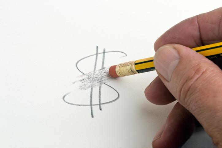 Borracha apagando símbolo de cifrão escrito em papel